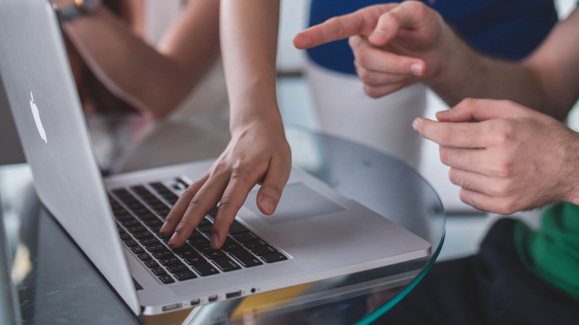 Close up of people working around a laptop