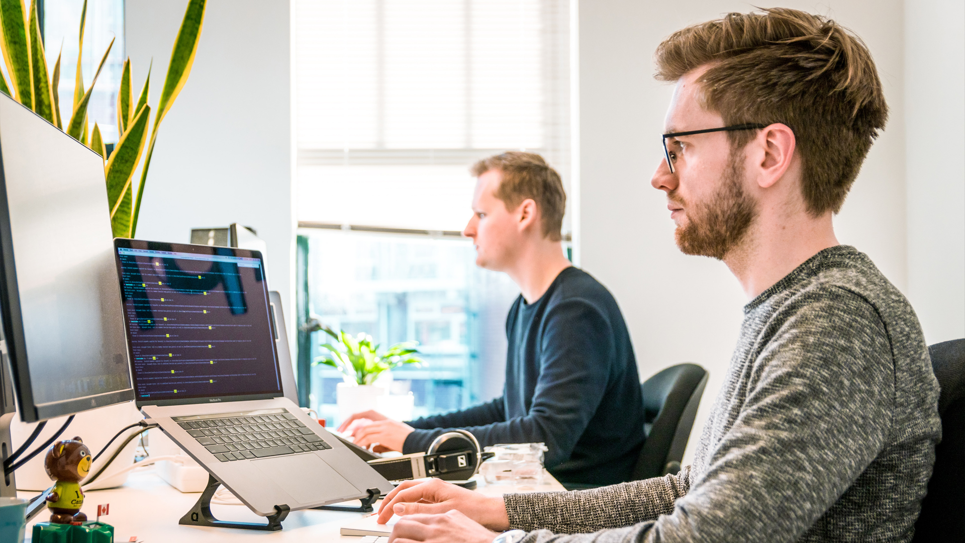 Two men sat at desks using computers